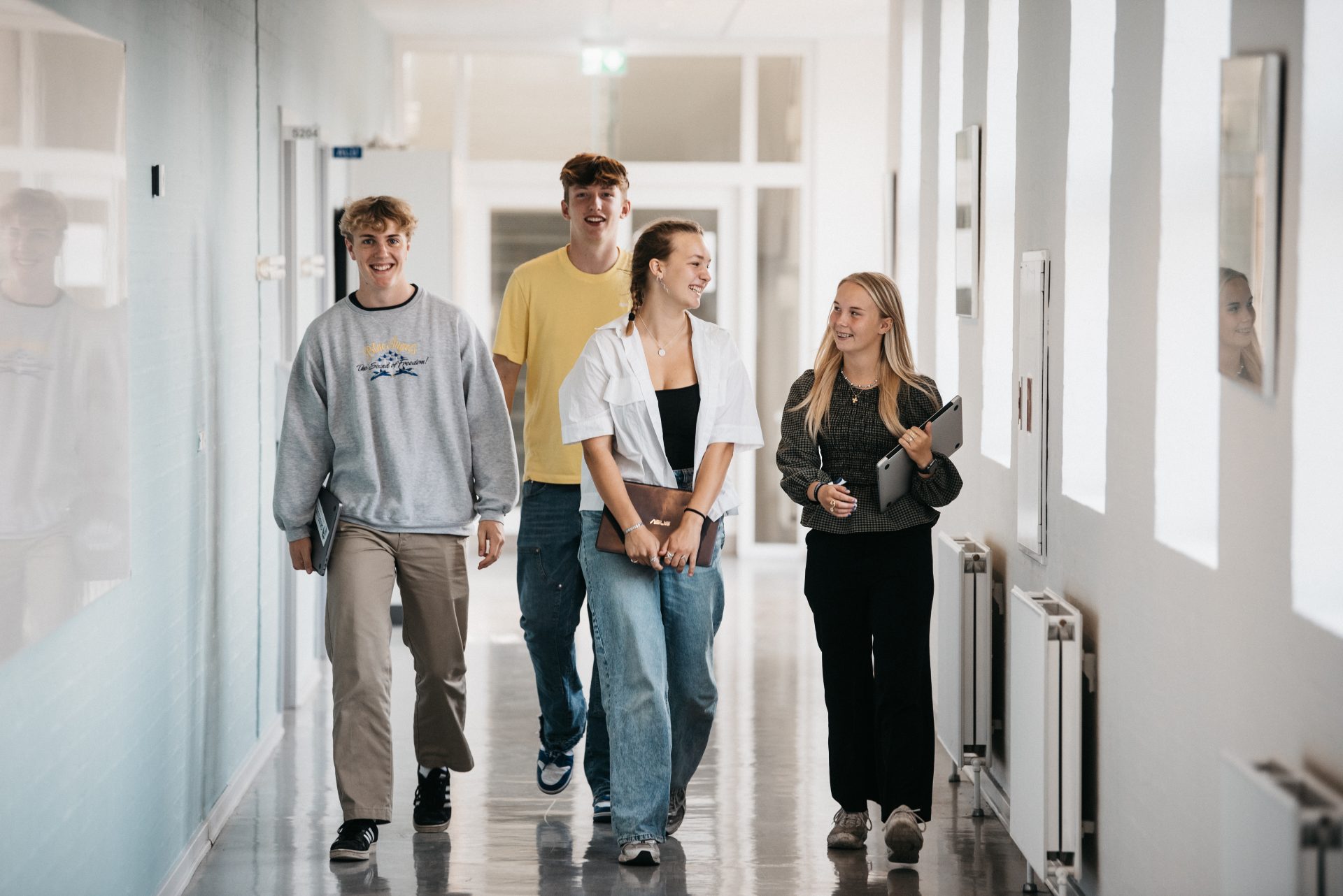 4 elever kommer gående på gangen