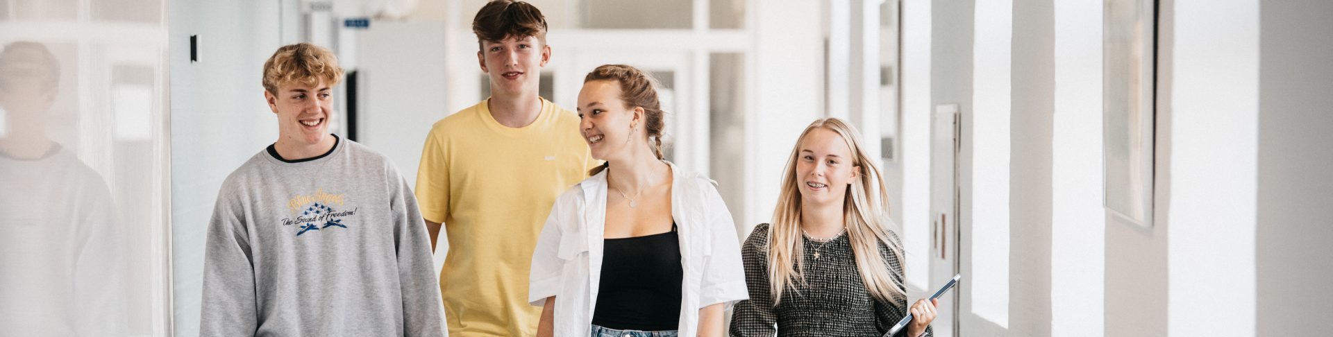 4 elever kommer gående på gangen
