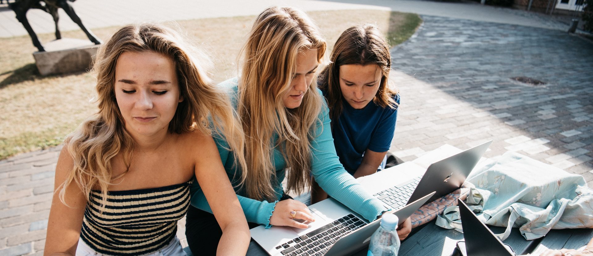 3 elever laver lektier i skolegården