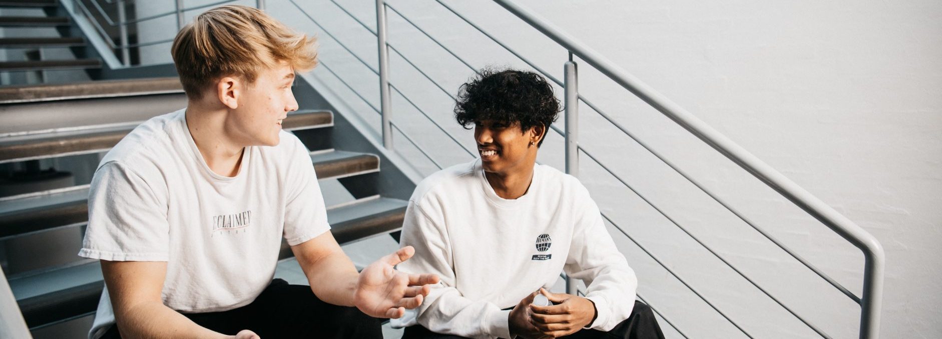 2 elever sidder på trappe