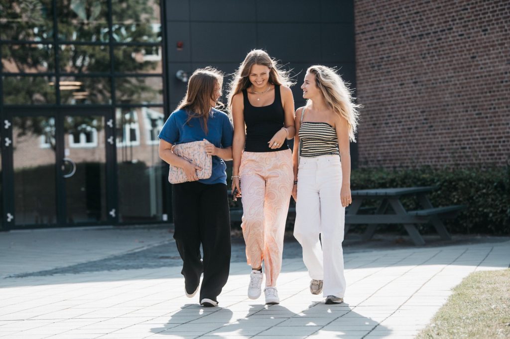 3 elever som kommer gående i skolegården