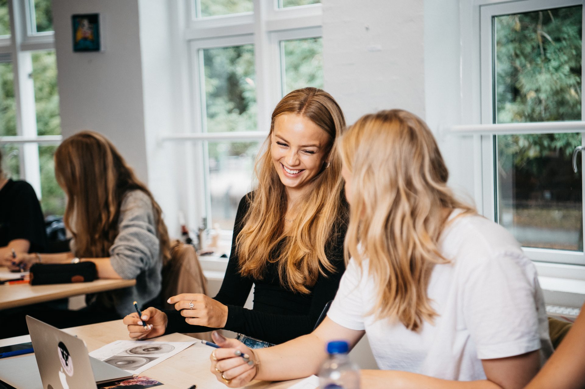 2 piger som har billedkunst og griner