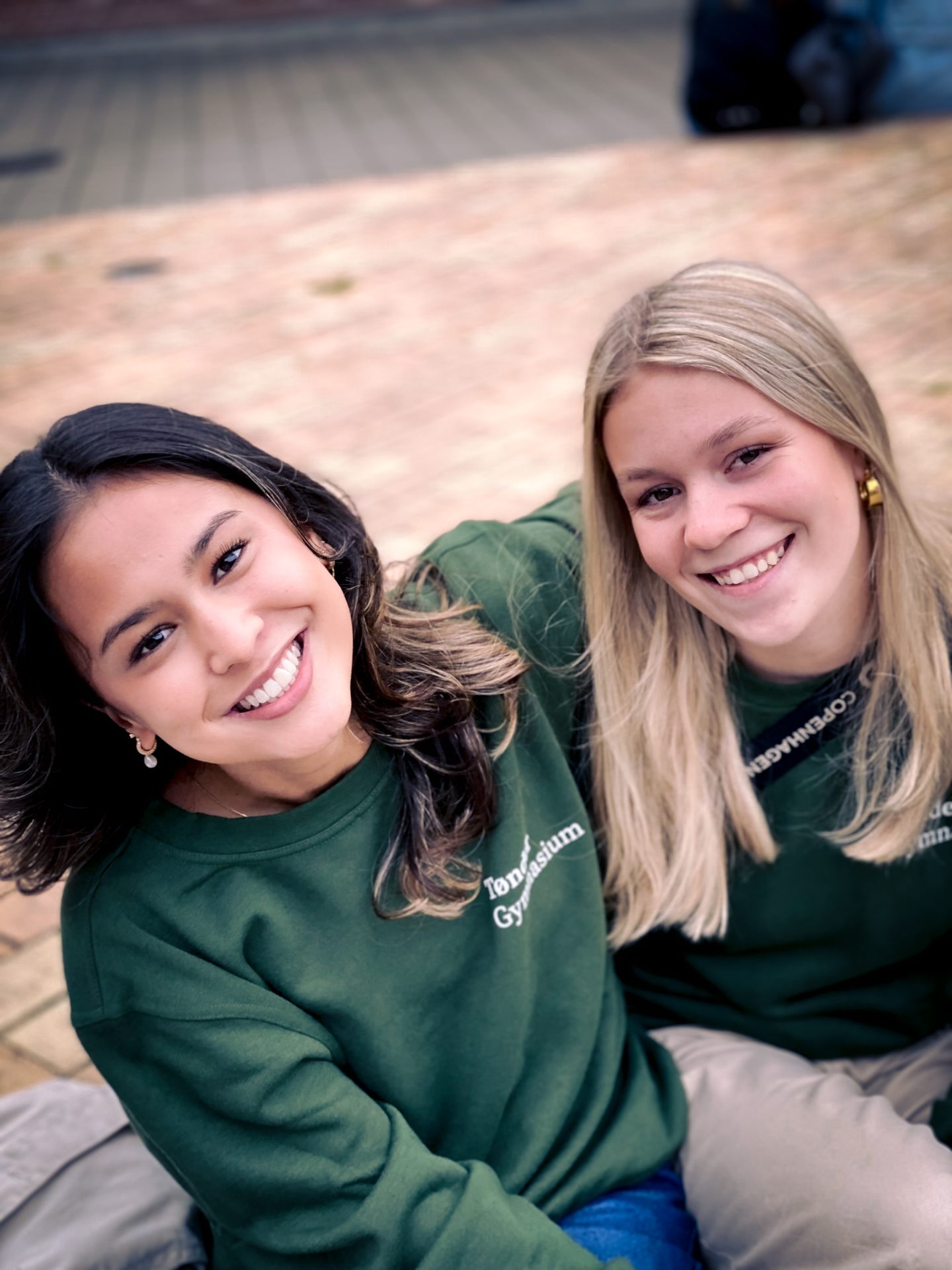 2 elever sidder i skolegården